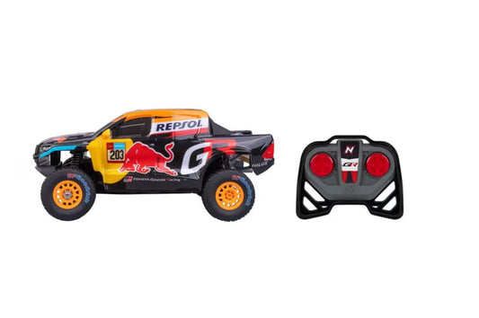 Side view of Nikko Pro Trucks Toyota Gazoo Racing Hilux Dakar RC truck next to its remote